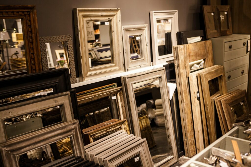 A collection of vintage-style mirror frames on display in a cozy interior shop setup.